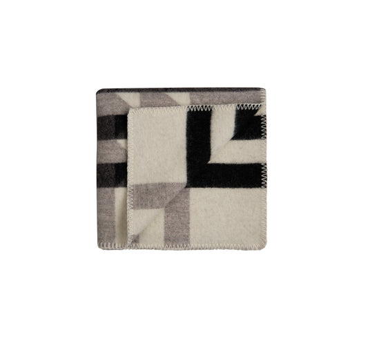 Kvam Halvpledd i sort fra Røros Tweed, et sofistikert og tidløst ullpledd. Den mørke tonen gir et elegant preg til rommet, perfekt for både koselige stunder og som et stilfullt interiørtilbehør.