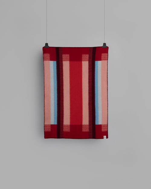 Mikkel Rød Halvpledd fra Røros Tweed, et vakkert ullpledd i varme røde nyanser. Perfekt for å tilføre både farge og komfort til hjemmet, og ideelt for kalde vinterkvelder.