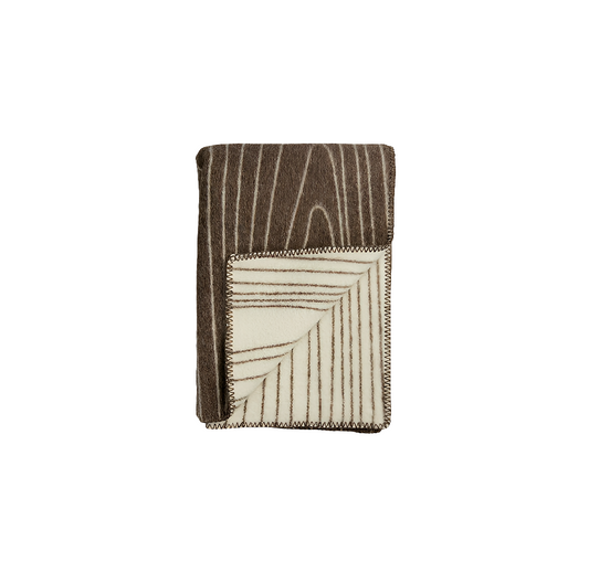 Skog Brun Ullpledd fra Røros Tweed, et luksuriøst og varmt pledd laget av 100% ull. Dette tidløse designet kombinerer den naturlige brunfargen med mykhet og varme, og gir både stil og komfort til hjemmet ditt. Perfekt for å holde varmen på kalde vinterdager eller som et dekorativt element i stuen. Pleddet er laget i Norge med fokus på kvalitet og bærekraft. En ideell gave til dem som setter pris på norsk håndverk og naturens skjønnhet.