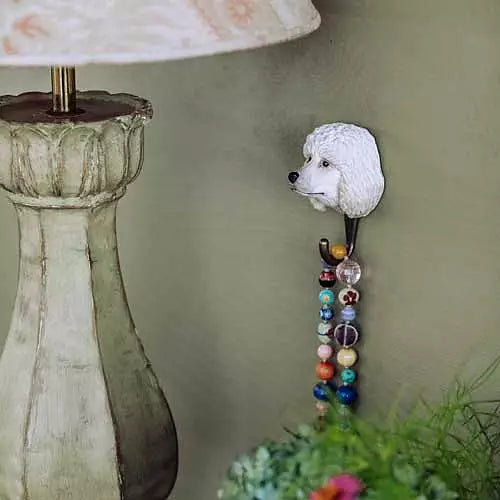 Puddel-Krok fra Snekkerbua, en sjarmerende jernkrok inspirert av puddelhunden. Denne håndlagde kroken fanger den elegante og lekne naturen til puddelhunden, og fungerer både som et praktisk oppheng og som en unik dekorasjon i hjemmet. Perfekt for hundeelskere eller de som ønsker å tilføre et koselig og personlig preg på gangen, stuen eller kjøkkenet. Denne kroken er laget med kjærlighet og omtanke, og gir en perfekt kombinasjon av funksjon og estetikk.