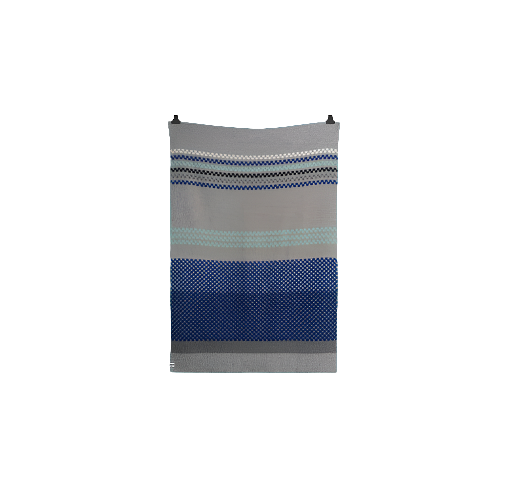 Toskaft grå med blått ullpledd fra Røros Tweed, tilgjengelig hos Snekkerbua. Et stilfullt og varmt pledd laget av høy kvalitet ull, perfekt for koselige stunder hjemme eller som et elegant tilskudd til innredningen.