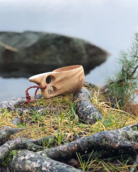 Trekopp med to hull og hank, laget av masurbjørk, perfekt for turbruk. Denne praktiske koppen kombinerer tradisjonelt håndverk med funksjonalitet. Ideell for friluftsliv og eventyr, håndlaget med kvalitet fra Snekkerbua.
